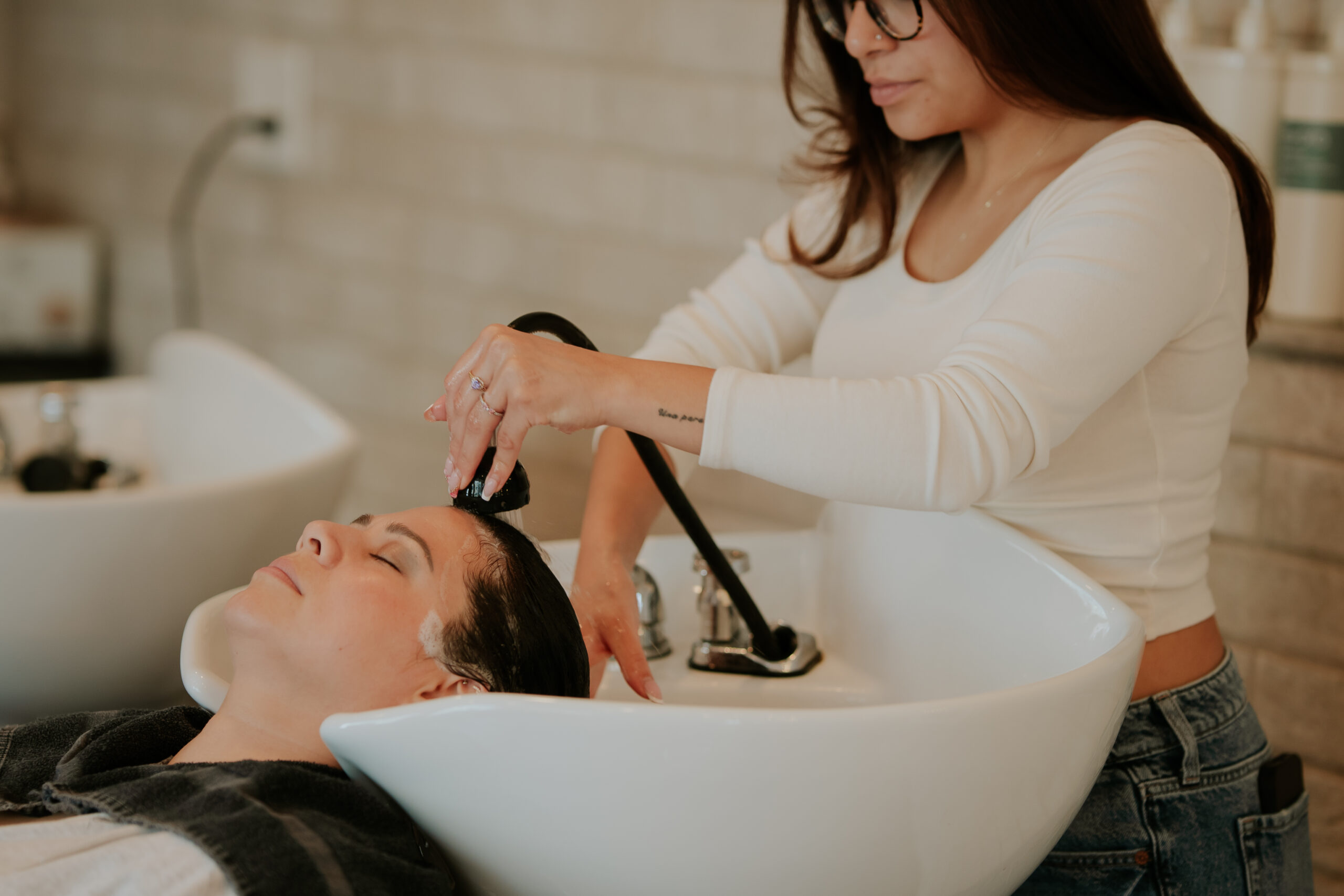 Hairstylist performing a blowout service at Philip Edward Salon in Charlestown Boston